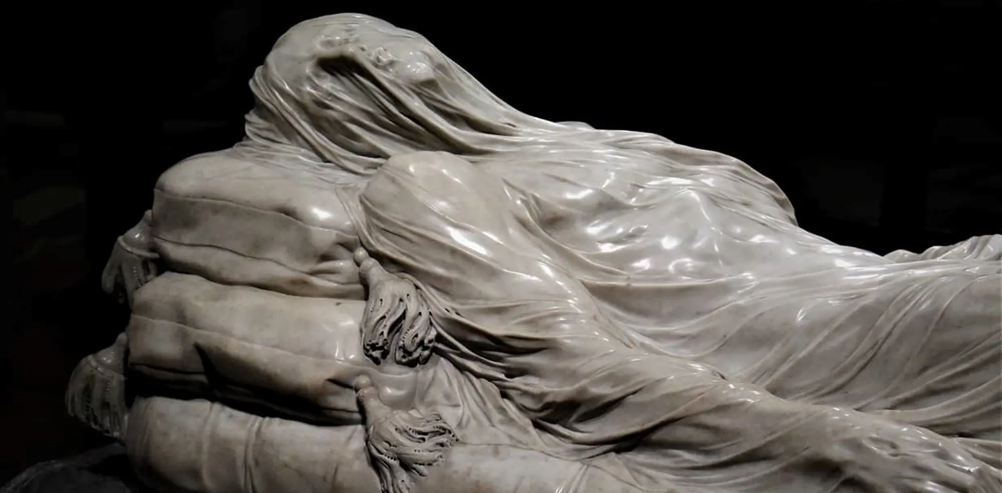 Detail of the Veiled Christ, a marble figure lying beneath a carved veil